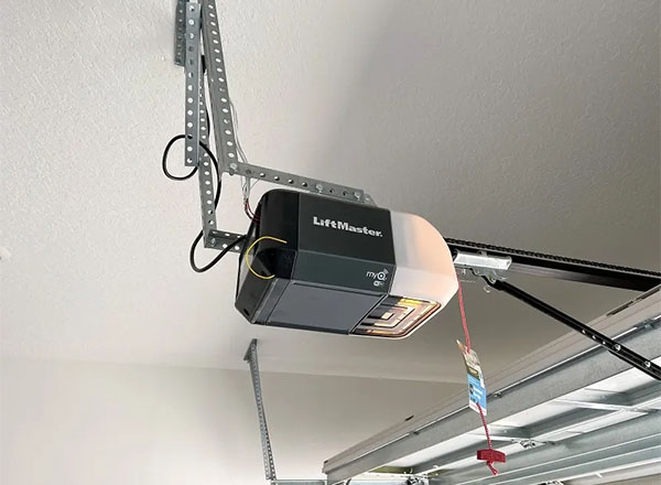 LiftMaster garage door opener installed on the ceiling with a metal support bracket.