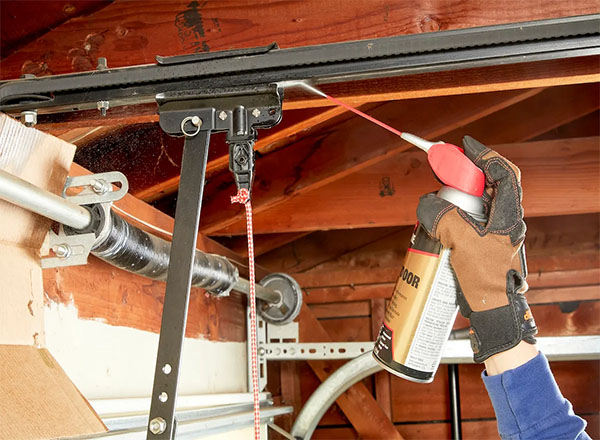 A technician applying high-quality lubricant to a garage door track and rollers to reduce friction, prevent wear, and ensure smooth operation. A technician applying high-quality lubricant to a garage door track and rollers to reduce friction, prevent wear, and ensure smooth operation. A technician applying high-quality lubricant to a garage door track and rollers to reduce friction, prevent wear, and ensure smooth operation.