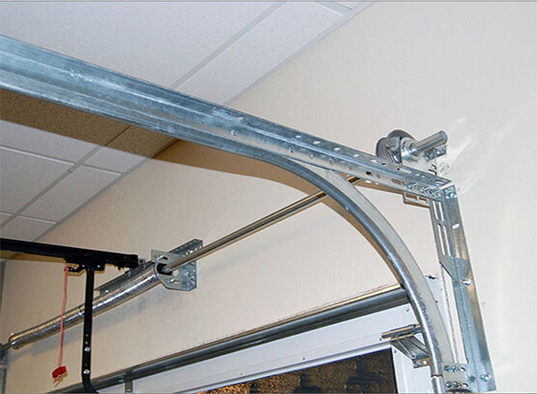 Close-up view of a standard garage door track system, including metal brackets, rollers, and a curved rail for smooth door operation.