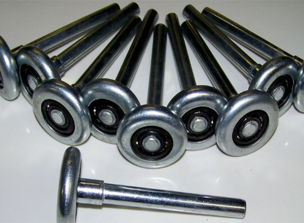 A set of steel garage door rollers with ball bearings, arranged in a semi-circle on a white surface, used for smooth and durable operation of garage doors.