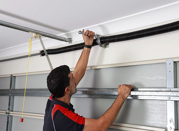 A garage door technician performing a tension test on a torsion spring, ensuring proper balance and safe operation of the door. A garage door technician performing a tension test on a torsion spring, ensuring proper balance and safe operation of the door. A garage door technician performing a tension test on a torsion spring, ensuring proper balance and safe operation of the door.